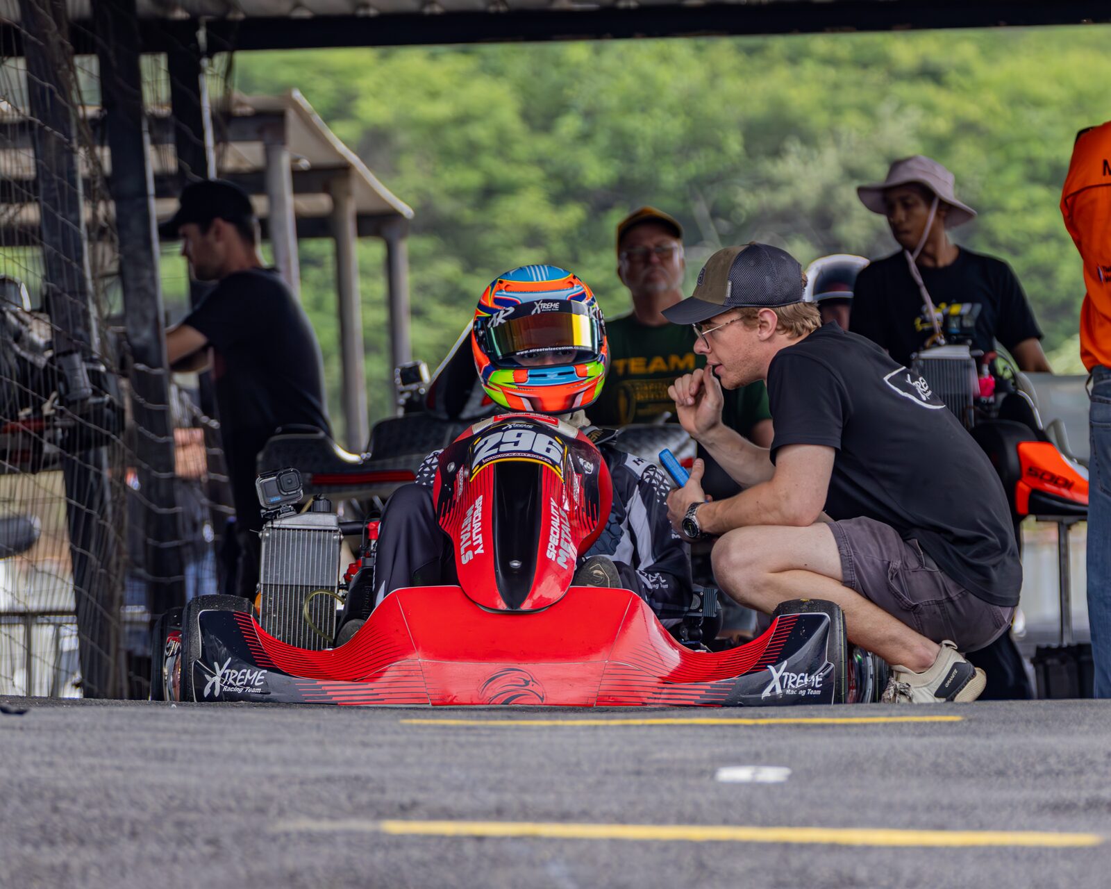 Jonno Wilson in the pit lane, pre-race briefing with coach, Xtreme Racing Team